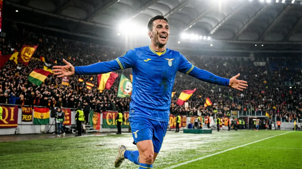 Delantero celebrando un gol en un estadio de la Ligue 1 con los brazos abiertos frente a la afición